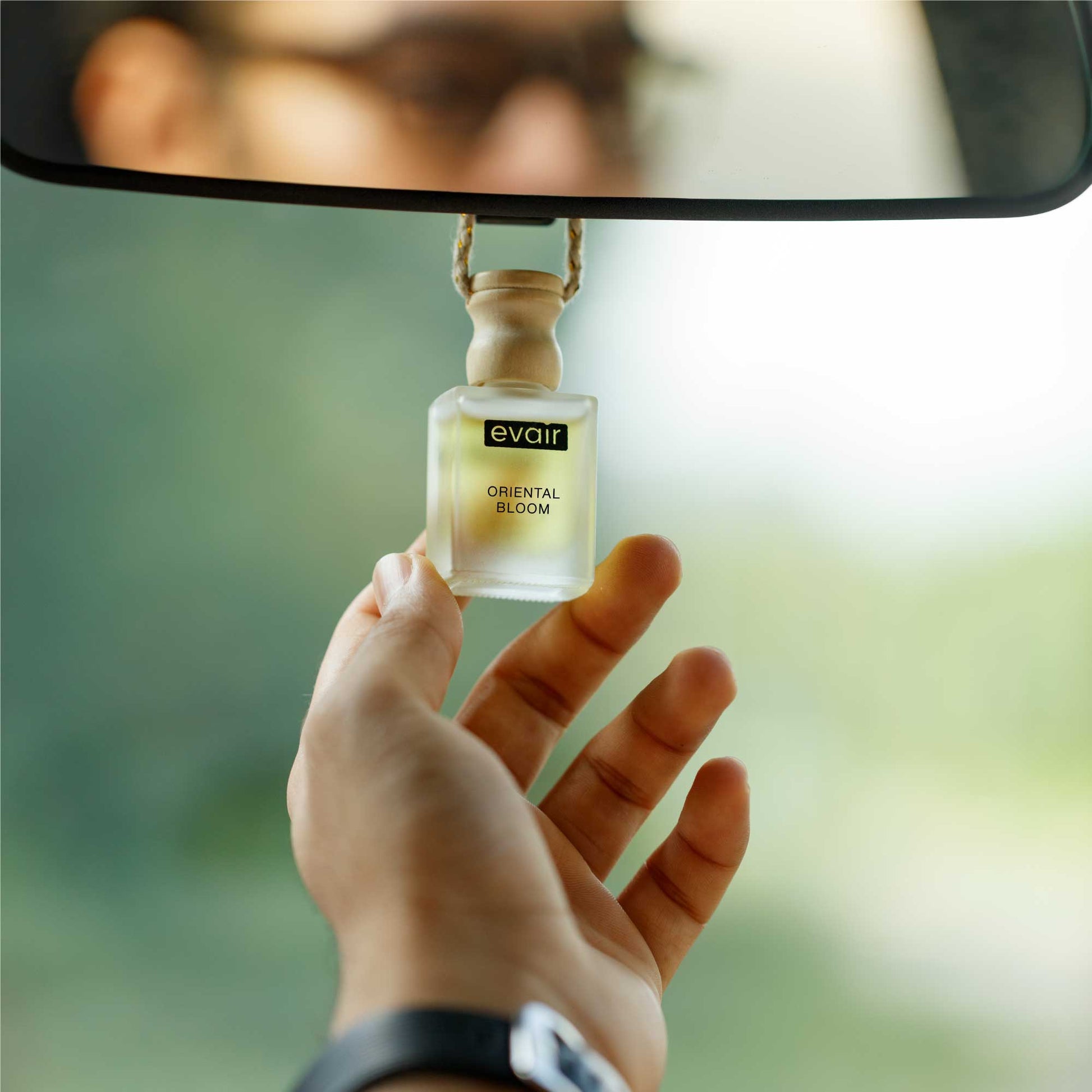 Man Holding Oriental Bloom Hanging Car Air Freshener in the Hand